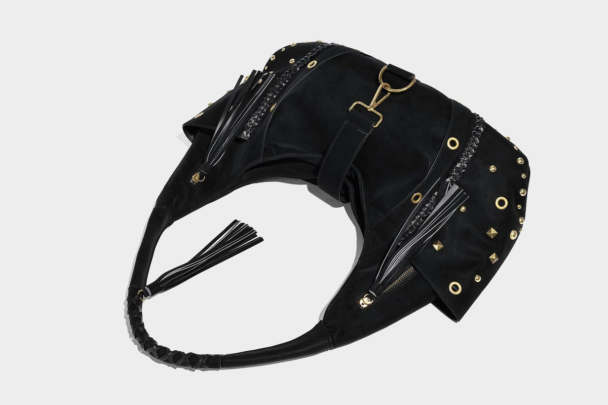 Slouchy crescent hobo bag in matte brown suede-like finish with gold-tone studs, grommets, braided top handle, tassel side