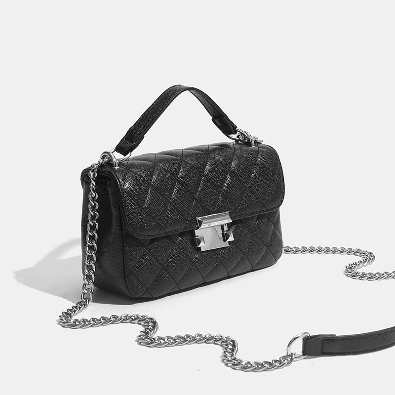 Kleine strukturierte Schultertasche mit Rautensteppung, doppeltem silberfarbenem Kettenriemen und rechteckigem silberfarbenem Verschluss, Detailansicht