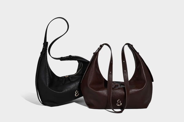 Lässig fallende, sichelförmige Hobo-Schultertasche in glatter dunkelbrauner Lederoptik mit Logo-Anhänger in Goldoptik und verstellbarem Schulterriemen