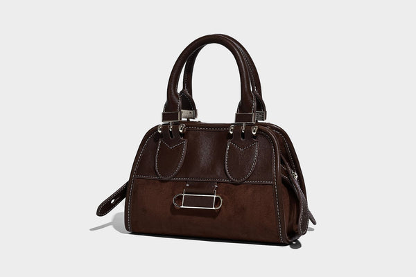 Kleine strukturierte Henkeltasche mit abgerundeten Tragegriffen, kontrastierenden weißen Steppnähten, Riegelverschluss in Silberoptik und abnehmbarem