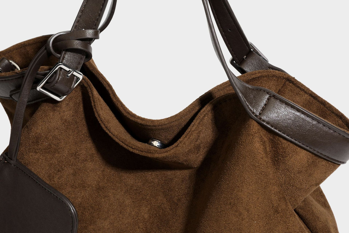 Große, weich fallende Tote aus Wildlederoptik in warmem Braun mit dunklen glatten Besätzen, zwei Tragegriffen, abnehmbarem Reißverschluss-Etui und, Detail
