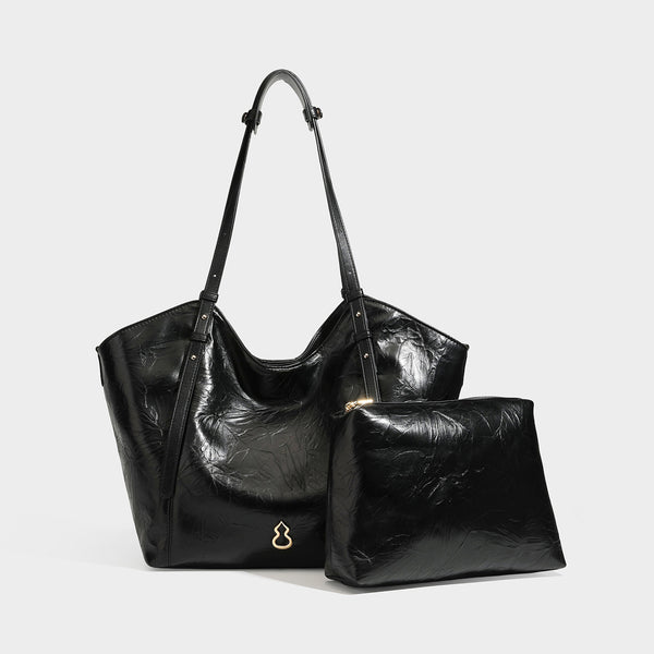 Große, glänzende Tote-Bag in geknitterter schwarzer Lederoptik mit lässiger Trapezform, zwei Schulterriemen und goldfarbenem