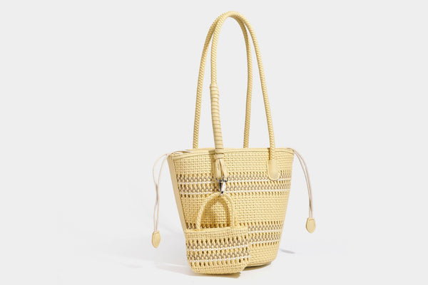 Light blue open-weave woven bucket tote bag with long braided shoulder straps, drawstring side ties, and attached mini pouch