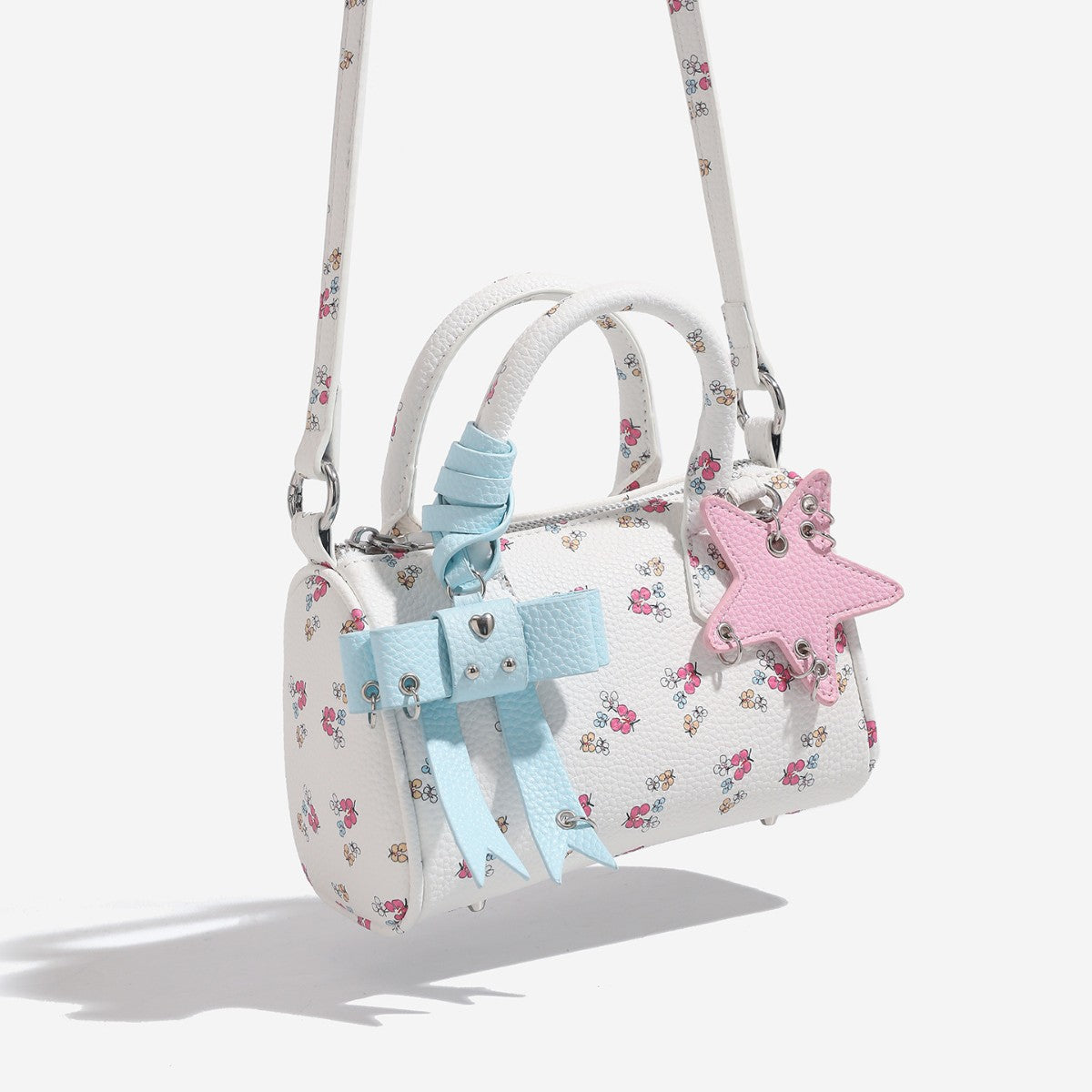 Mini white pebbled-finish Boston satchel with floral or cherry print, pastel blue bow charm, pink star charm, dual top