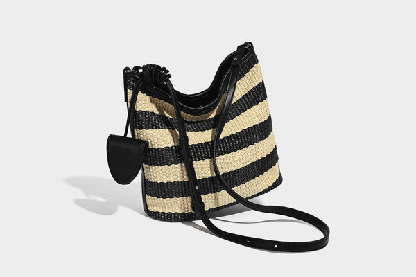 Gestreifte gewebte Bucket Bag in Schwarz und Beige mit schwarzem Besatz in Lederoptik, offener Oberseite und langem verstellbarem Schulterriemen, Detailansicht