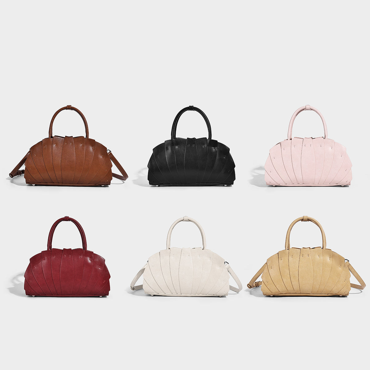 Structured dome satchel with fan-pleated leather-look exterior, dual top handles, and detachable shoulder strap, detail view