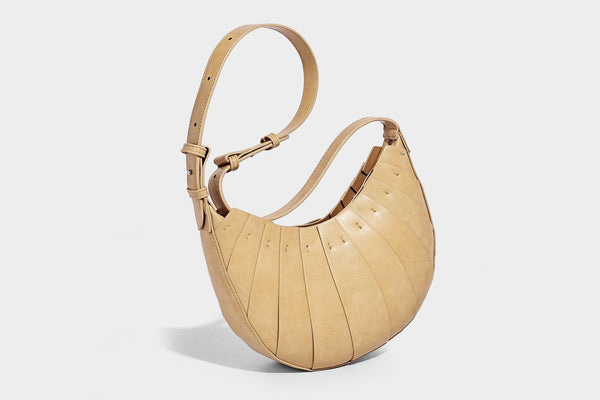 Crescent half-moon shoulder bag with vertical panel seaming, matte-satin leather-look finish, and adjustable gold-tone