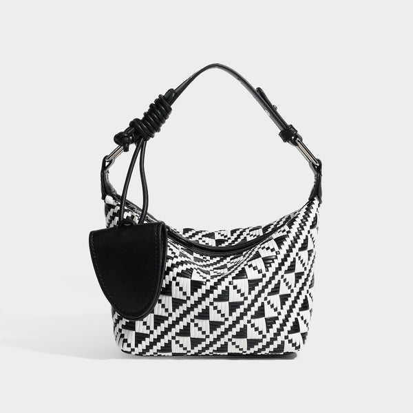 Kleine gewebte Schultertasche mit geometrischem Schwarz-Weiß-Muster, glatten dunkelbraunen Details in Lederoptik, geknotetem verstellbarem Riemen, Seitenansicht