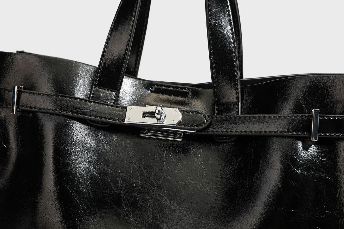 Strukturierte, glänzende Tote-Bag in Lederoptik mit silberfarbenem Drehverschluss, zwei Tragegriffen und abnehmbarem Schulterriemen, Detailansicht