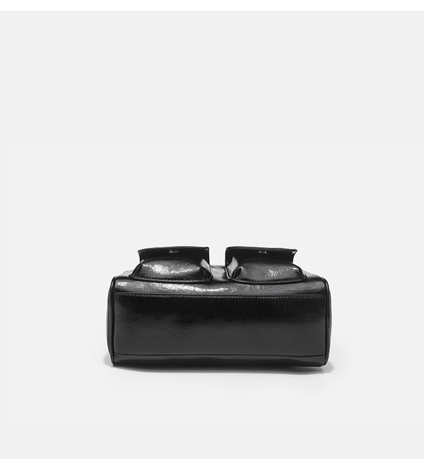 Structured glossy leather-look bowling shoulder bag with two front flap pockets, top zip closure, and long double shoulder