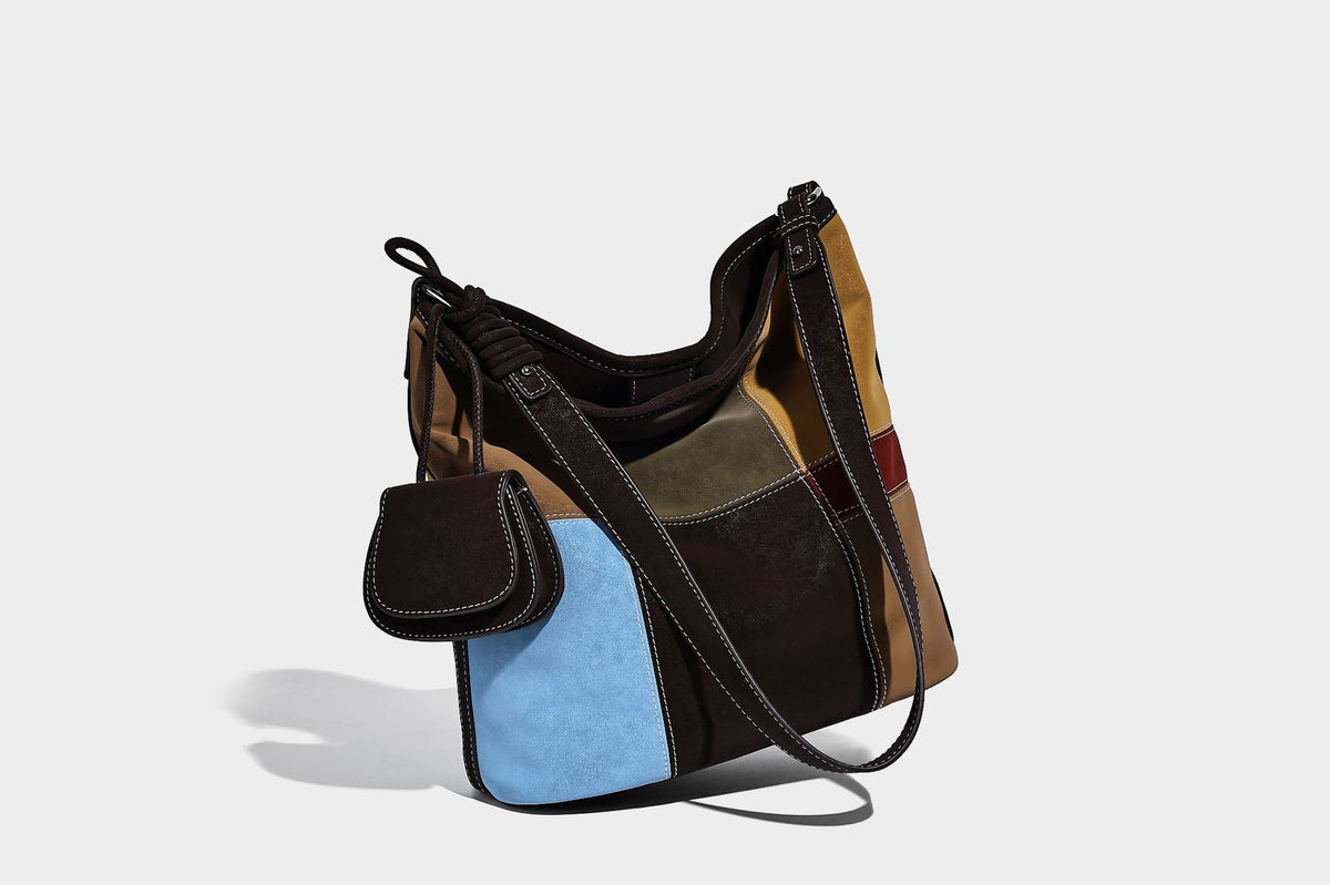 Weich fallende Patchwork-Bucket-Schultertasche mit Einsätzen in Dunkelbraun, Cognac, Senfgelb, Olivgrün, Rot und Hellblau sowie Kontrastnähten
