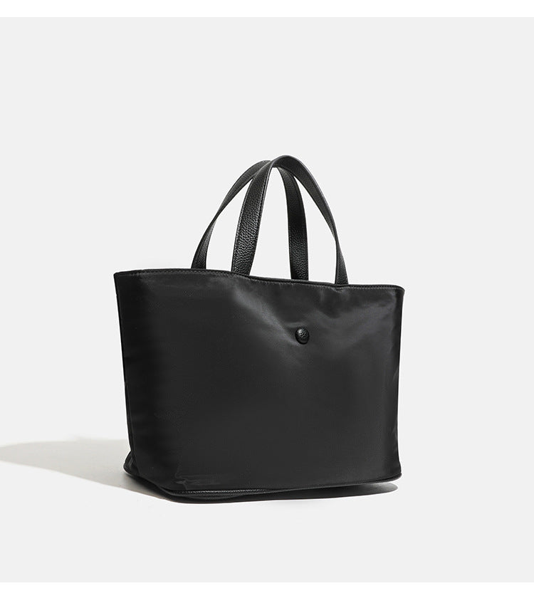 Structured lightweight nylon tote bag with textured double top handles and snap-button front detail, detail view 14