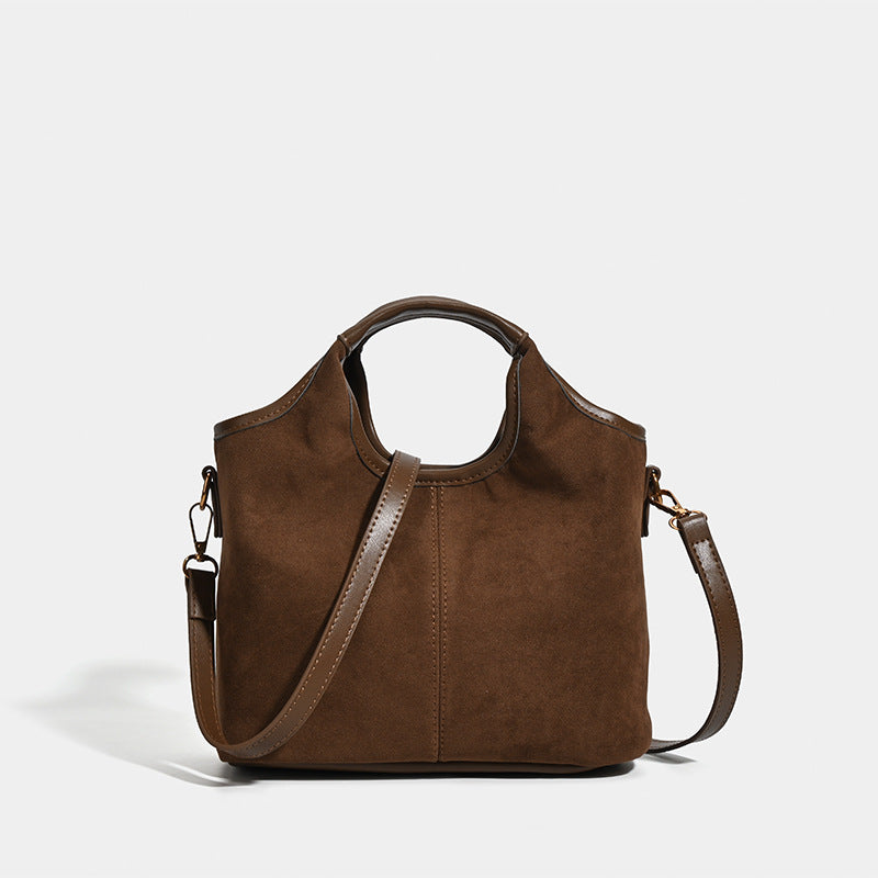 Wandelbarer Shopper in mattem Schokoladenbraun mit Velourslederoptik, abgerundeten Henkeln und abnehmbarem Schulterriemen, goldfarbene Details