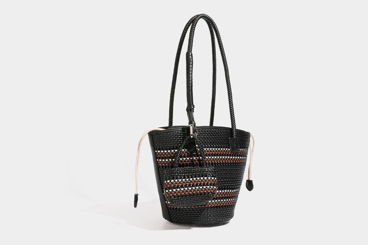 Light blue open-weave woven bucket tote bag with long braided shoulder straps, drawstring side ties, and attached mini pouch