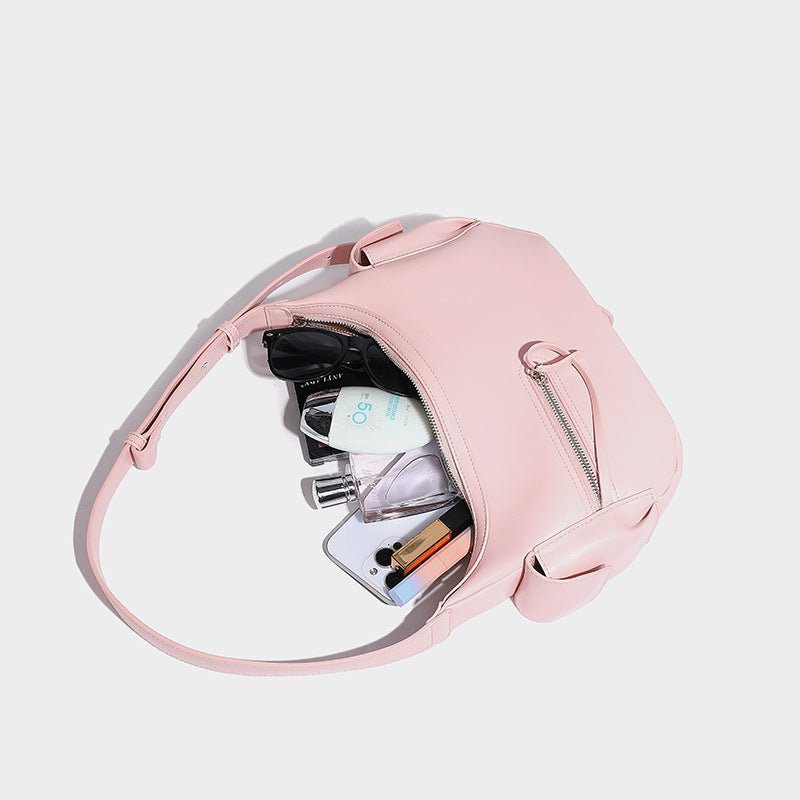 Smooth leather-look crescent shoulder bag with front zip pocket, side flap pockets, adjustable strap, and silver-tone, detail