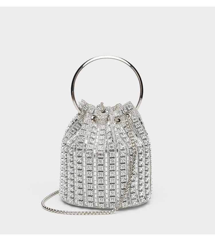 Mini crystal rhinestone bucket bag with circular ring top handle, drawstring closure, and silver chain shoulder strap, detail