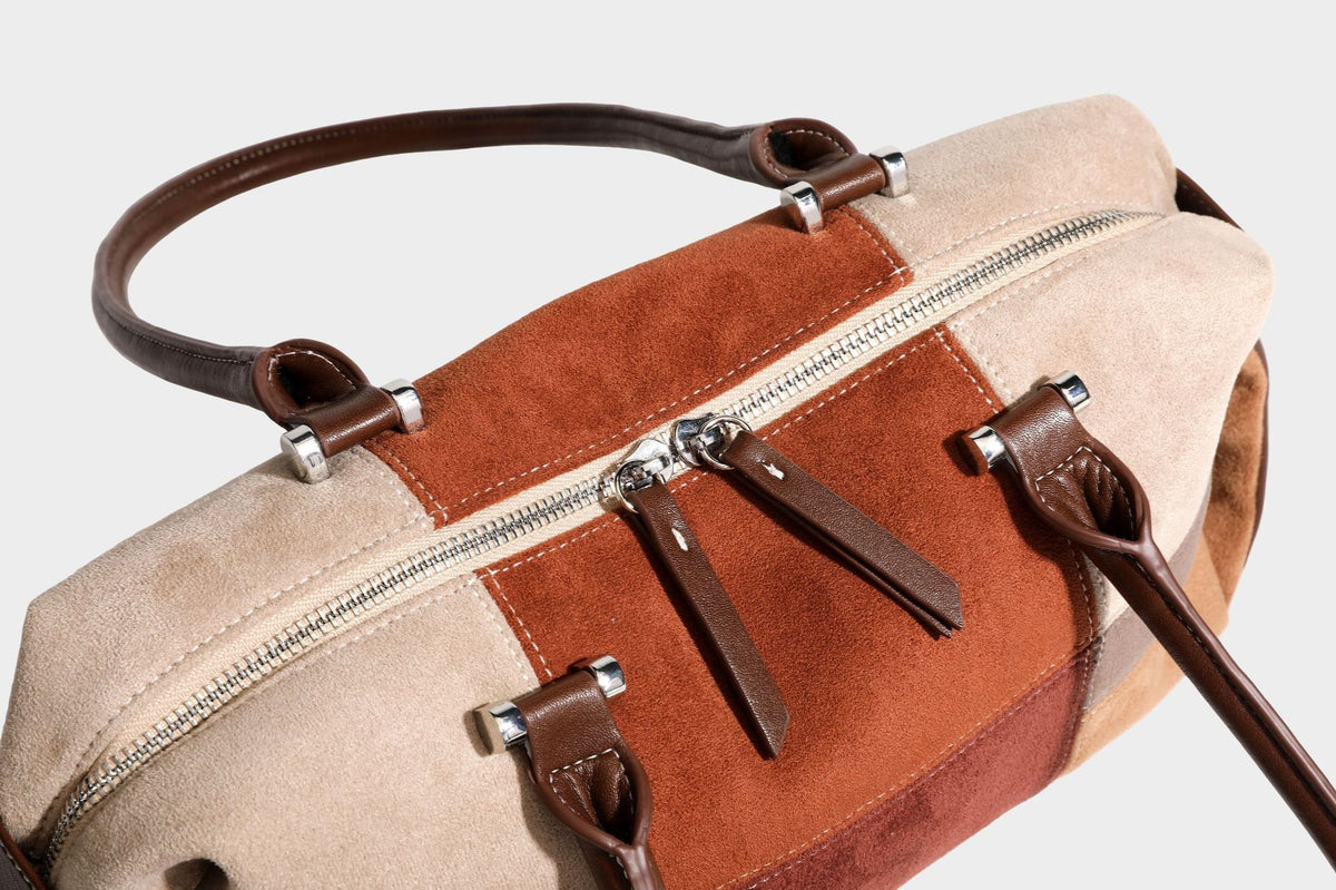 Patchwork suede-look barrel shoulder bag in brown, rust, tan, beige, and gray panels with double leather-look straps and