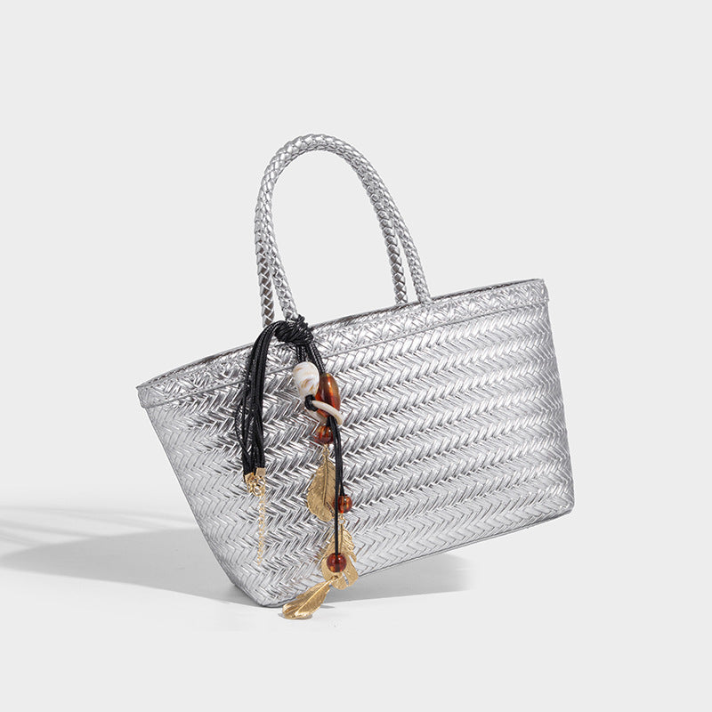 Structured chevron woven leather-look tote bag with braided top handles, gold feather charm, and adjustable shoulder strap