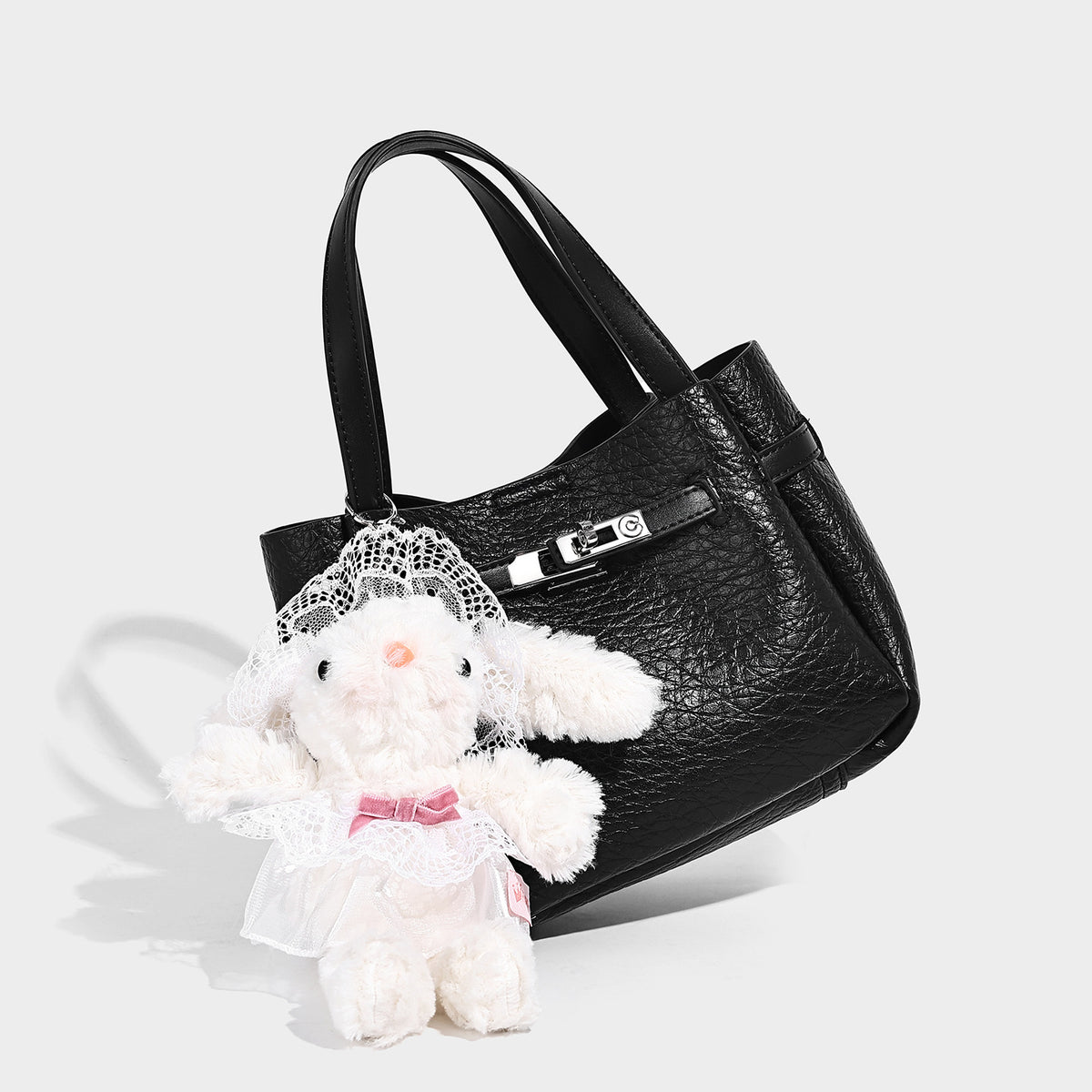 Small structured pebbled bucket tote with double top handles, silver turn-lock hardware, and detachable shoulder strap