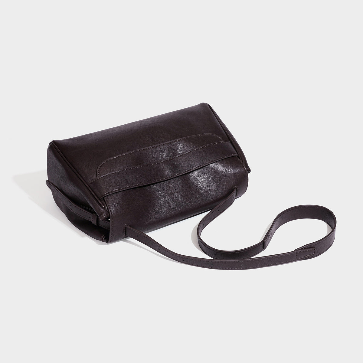 Structured rectangular flap shoulder bag in dark brown leather-look finish with long single strap and layered front panel