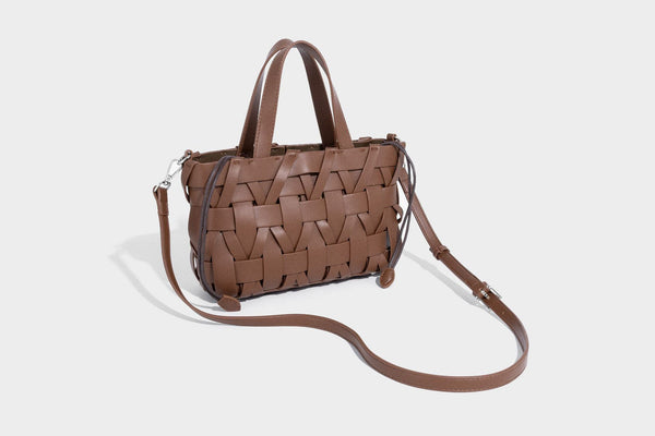 Structured woven basket tote handbag with contrasting dark trim, double top handles, detachable shoulder strap, and