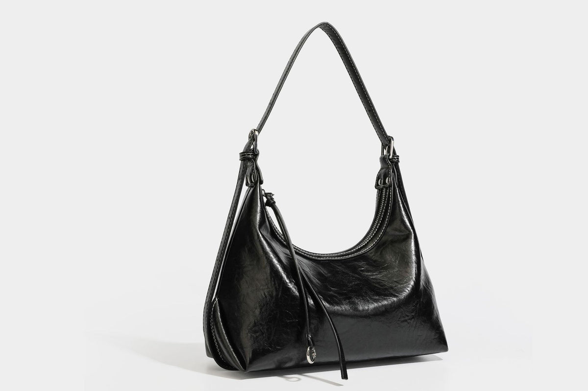 Slouchy hobo shoulder bag in glossy crinkled leather-look finish with zip-top closure and silver-tone ring hardware, detail