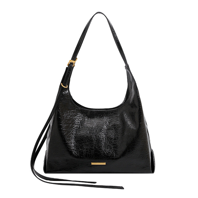 Slouchy hobo shoulder bag in crinkle high-gloss leather-look finish with gold-tone bar hardware and adjustable strap, detail
