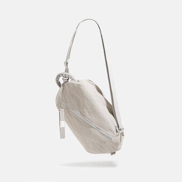 Lässige Crossbody-Bag aus weichem Stoff mit geflochtenem Kordel-Tragegriff, diagonalem Reißverschlussfach auf der Vorderseite und silberfarbenen Details, Detailansicht