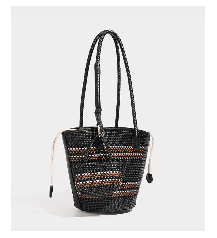 Structured woven bucket tote bag in pastel blue with braided shoulder strap, open lattice weave body, cream drawstring
