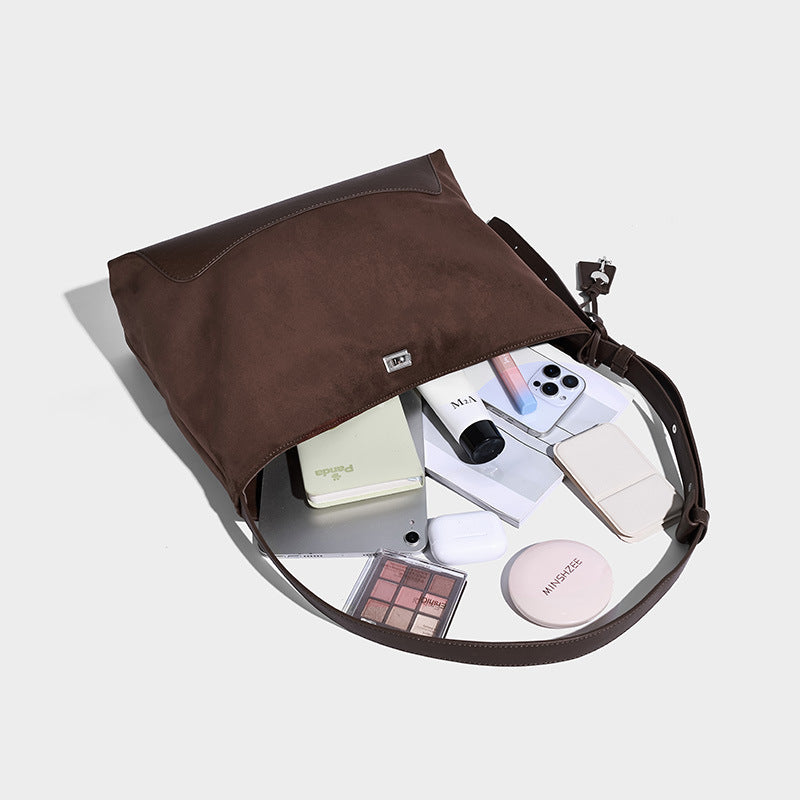 Dark brown slouchy hobo bag with matte suede-look body, smooth leather-look base trim, adjustable shoulder strap, and, detail