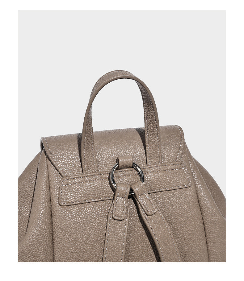 Compact pebbled leather-look flap drawstring backpack handbag with side pockets, top handle, and silver-tone hardware, detail