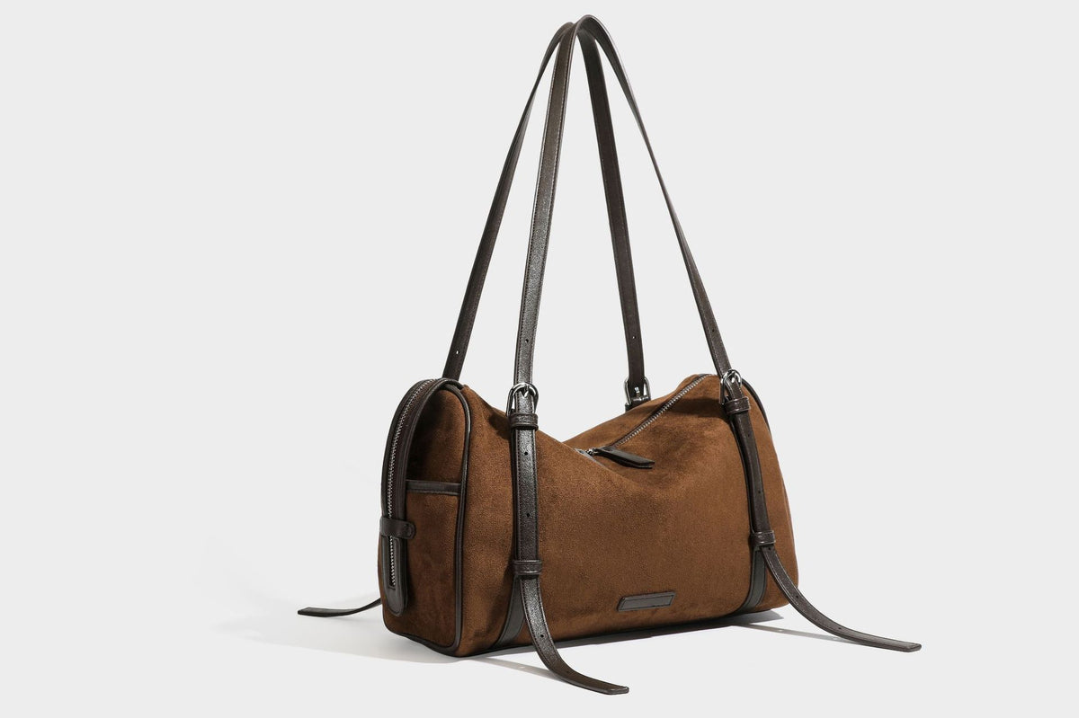 Large brown suede-finish barrel shoulder bag with dark leather-look trim, silver-tone zippers, dual top handles, and long