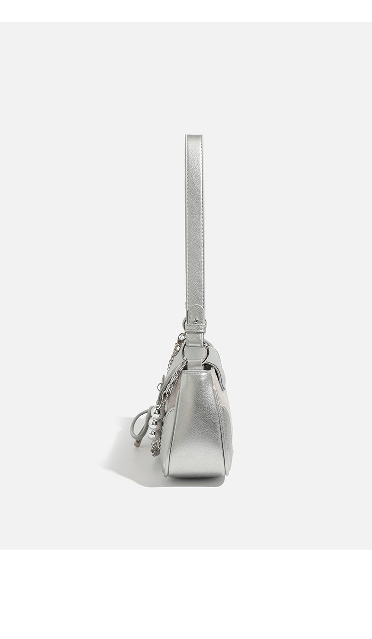 Compact silver flap shoulder bag with pale-pink crocodile-embossed panel, chain bead handle, bow charm, and adjustable