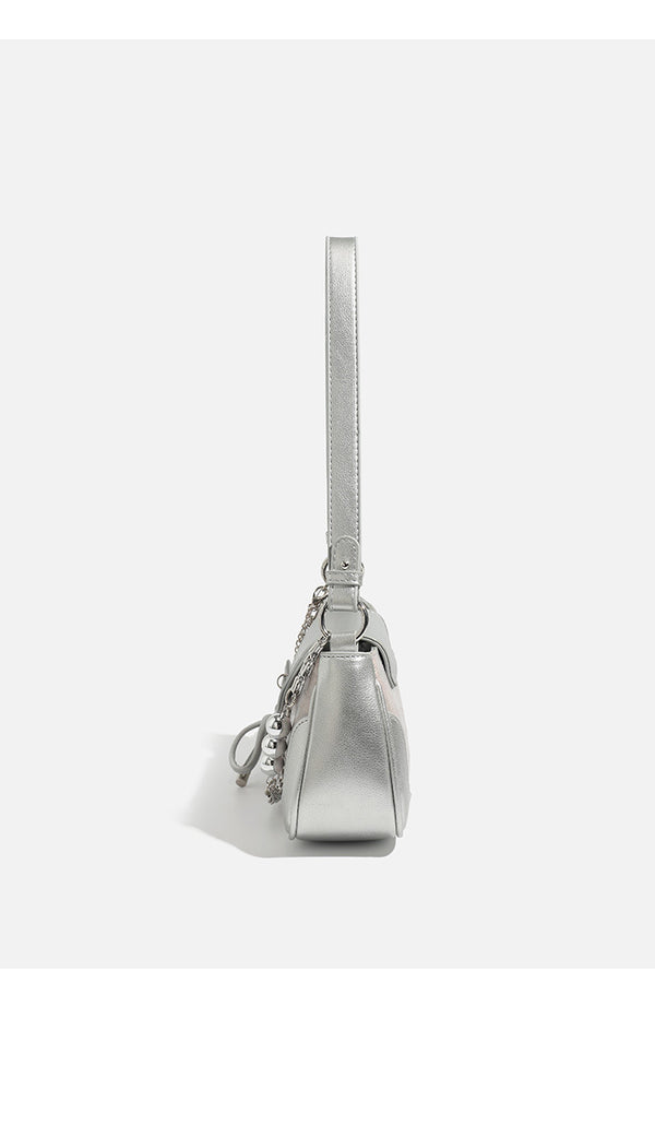 Compact silver flap shoulder bag with pale-pink crocodile-embossed panel, chain bead handle, bow charm, and adjustable