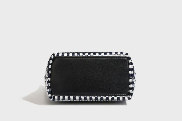 Small crescent shoulder bag in black-and-white woven textile with smooth black leather-look trim, zip-top closure, knotted