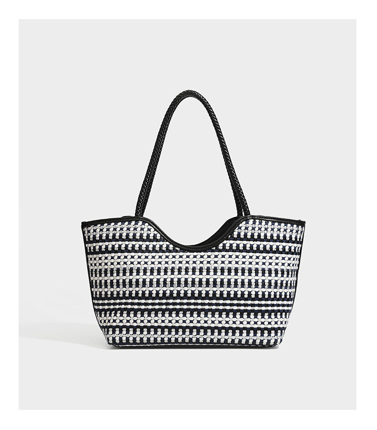 Large woven checker-pattern tote bag with dark braided shoulder straps, leather-look trim, and drawstring side ties, detail