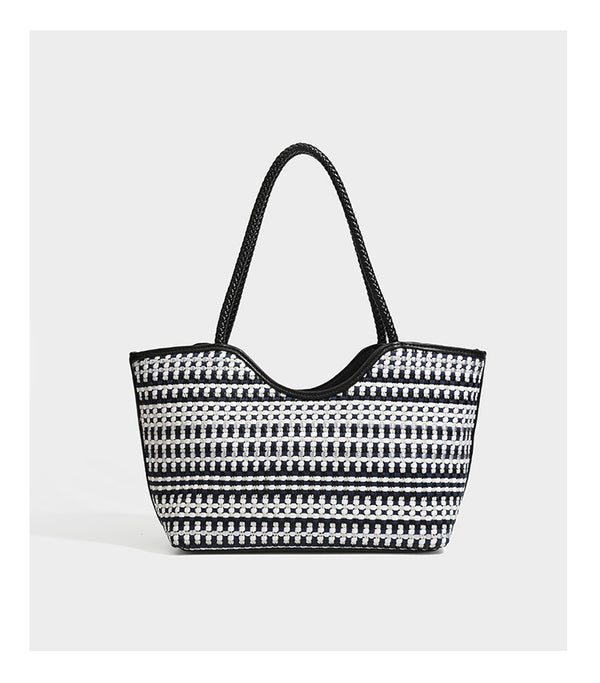 Large woven checker-pattern tote bag with dark braided shoulder straps, leather-look trim, and drawstring side ties, detail