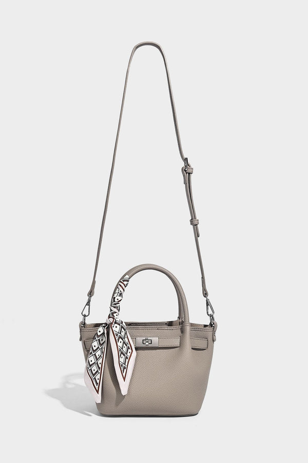 Kleine strukturierte Henkeltasche aus genarbtem Material in Taupe mit zwei Henkeln, bedrucktem Schalband, vorderem Drehverschluss und, Detail