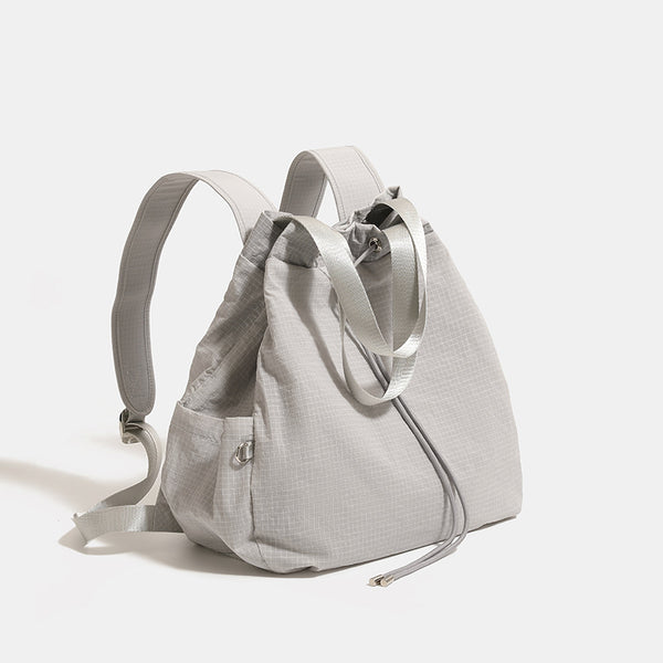 Glacier gray grid-texture nylon drawstring bucket convertible backpack with top handles and adjustable shoulder straps, front