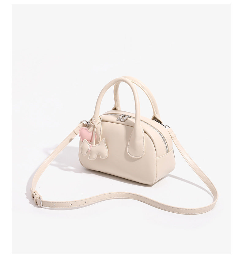 Mini-Handtasche in Kuppelform mit glatter Oberfläche in Lederoptik, zwei Henkeln, Reißverschluss oben, silberfarbenen Metalldetails und herabhängendem