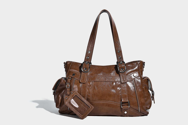Glossy structured black tote shoulder bag with silver buckle hardware, zip pockets, dual top handles, and detachable, detail