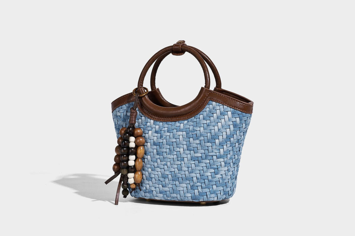 Blaue gewebte Bucket-Bag in Denim-Optik mit Besatz in brauner Lederoptik, rundem Henkel, Quastenanhänger mit Holzperlen und verstellbarem
