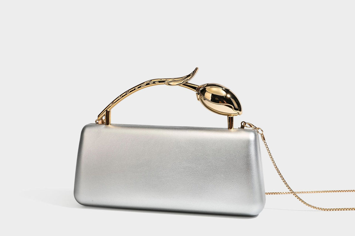 Strukturierte rechteckige Clutch mit goldfarbenem Henkel in Form einer Rosenknospe und abnehmbarem Kettenriemen in Metallic-Optik, Detailansicht