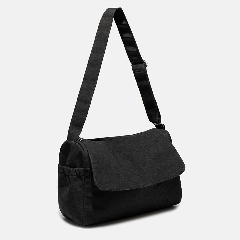 Große Messenger-Bag aus mattem schwarzem Canvas mit Frontklappe, Reißverschluss oben, elastischen Seitentaschen und verstellbarem silberfarbenem
