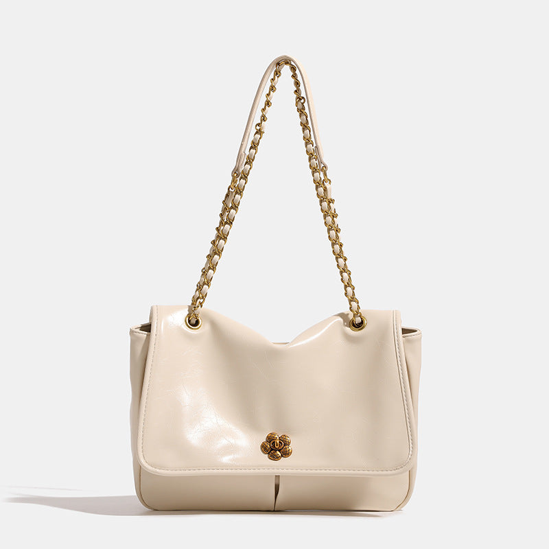 Structured flap shoulder bag with antique gold-tone chain strap and flower turn-lock clasp in crinkled leather-look finish