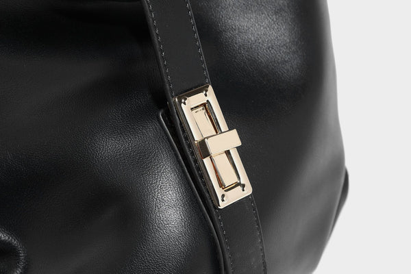 Soft slouchy hobo shoulder bag with smooth leather-look finish, gold-tone buckle and tab hardware, and long adjustable strap