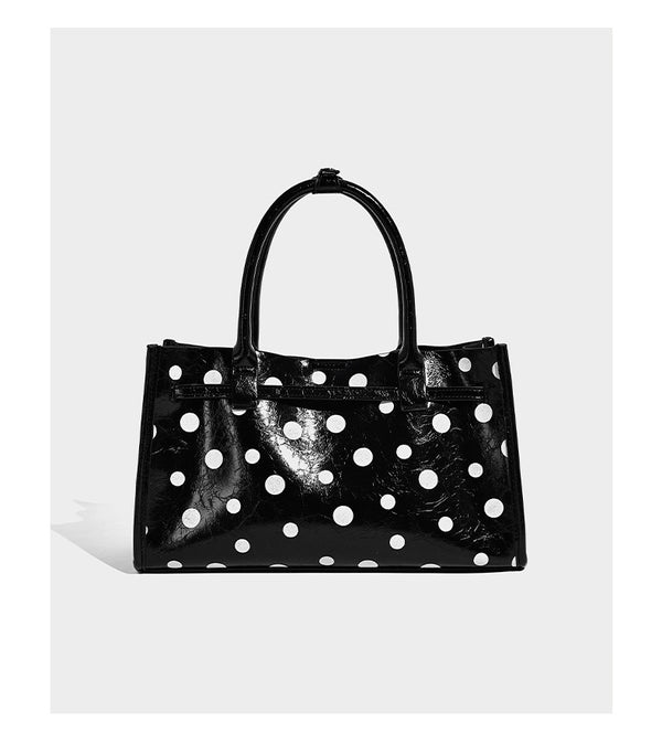 Structured glossy polka-dot tote bag with double top handles and front buckle hardware, detail view 10
