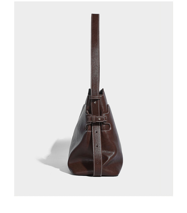 Large slouchy leather-look hobo tote bag with open top, adjustable shoulder strap, and colorful tassel bead charm, detail