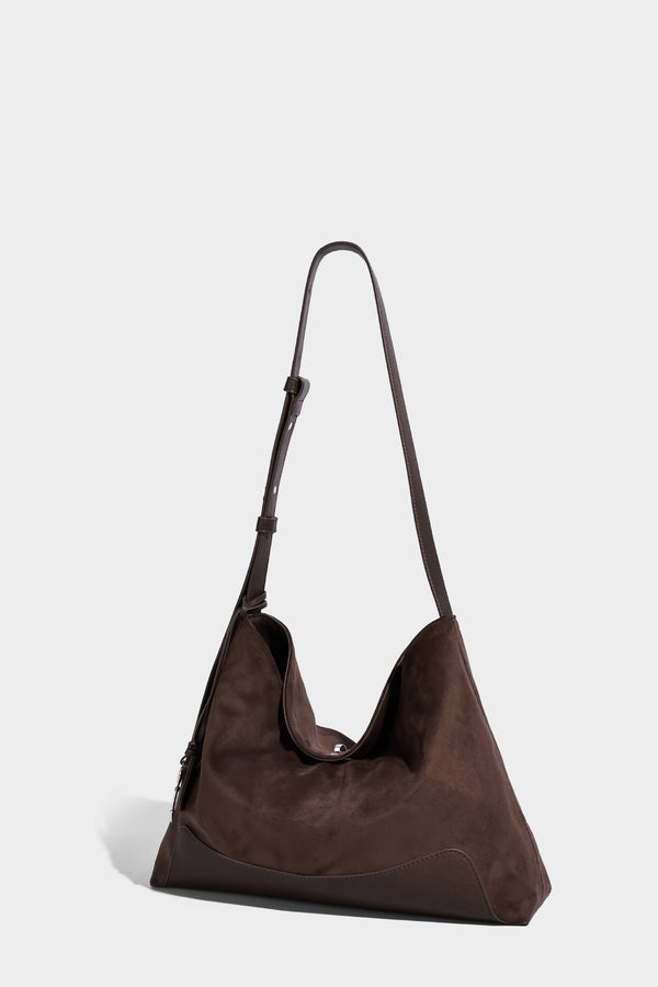 Dark brown slouchy hobo bag with matte suede-look body, smooth leather-look base trim, adjustable shoulder strap, and, detail