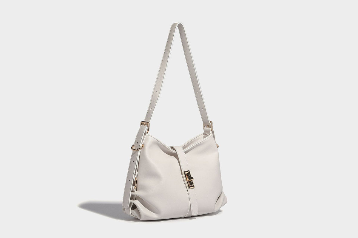 Soft slouchy hobo shoulder bag with smooth leather-look finish, gold-tone buckle and tab hardware, and long adjustable strap